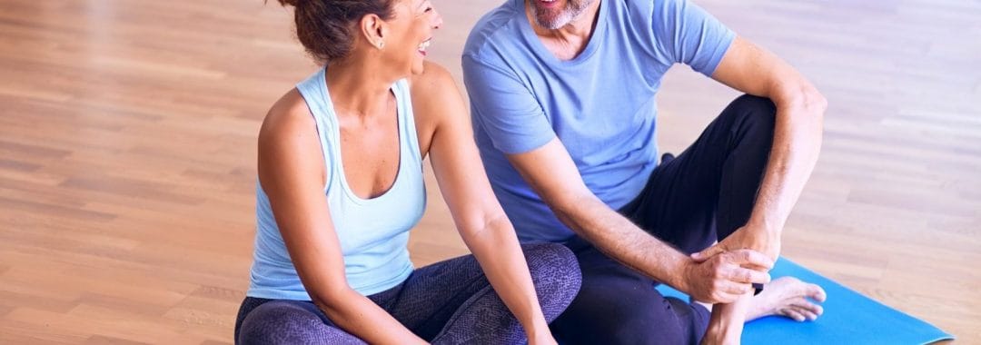 two fitness beginners sitting on an exercise mat discussing the 5 W's of exercise