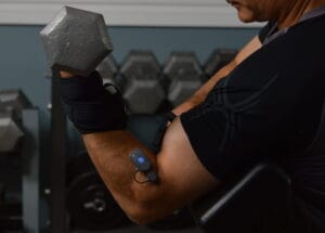 A man performing a preacher curl with EMG sensors on his long head of the biceps and brachioradialis